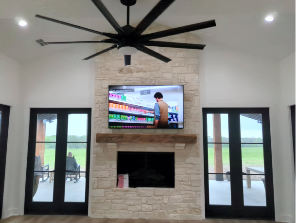 Living room with stone fireplace and mounted TV
