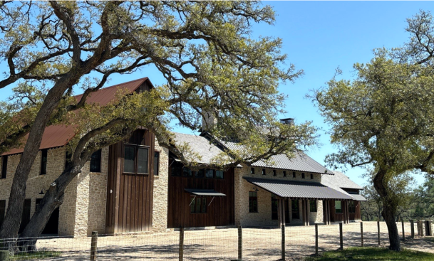 Large stone ranch-style home with metal roof